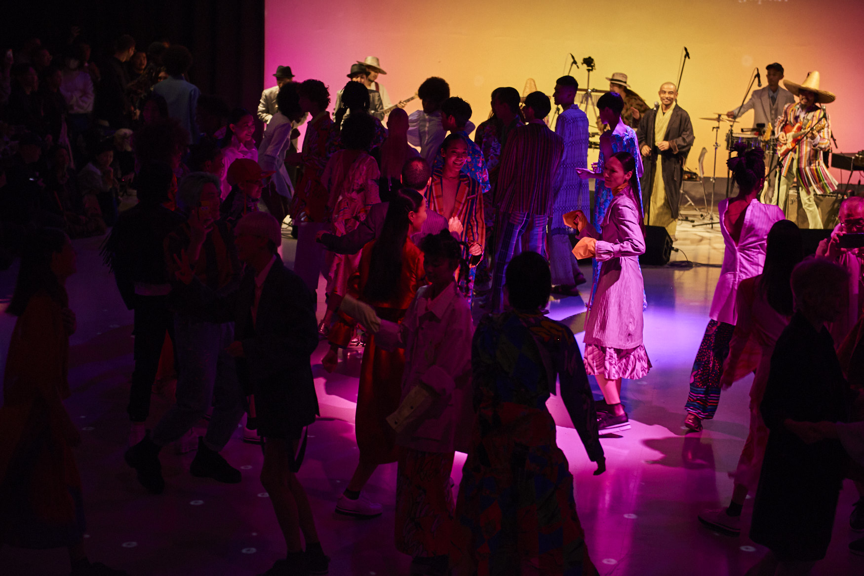 Crowd dancing with a band in the background