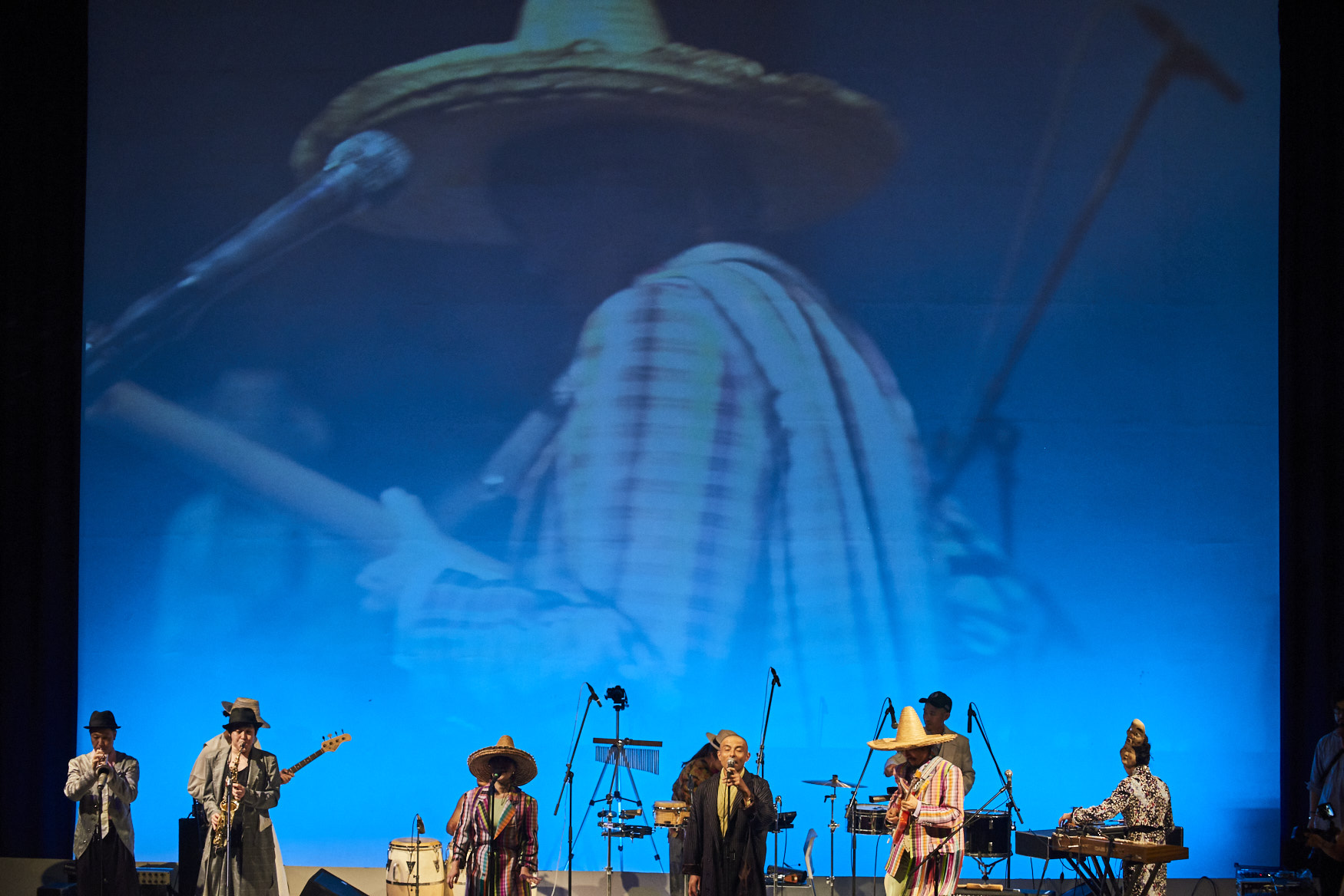 Band on stage with large screen background