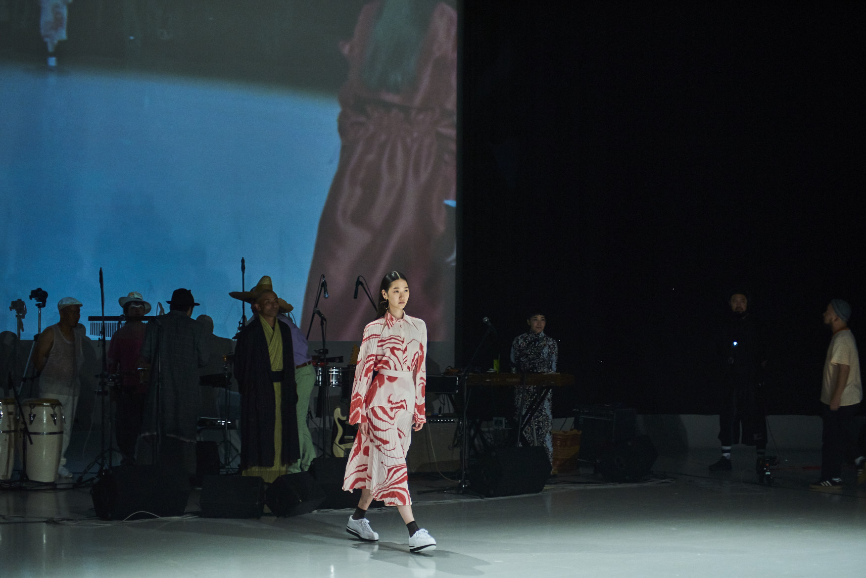 Model in dress with band in background